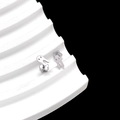 Detailed view of silver ghost-shaped stud earring on a white wavy stand over black background - Cute Ghost