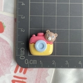 Gros plan d'une breloque en résine de 2 cm en forme d'appareil photo pour projets DIY - Appareil photo