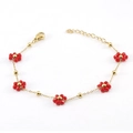 Elegante pulsera de cadena dorada con flores de cristal rojo sobre fondo blanco - Pulsera Roja