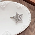Detailed close-up of a silver star hair clip with crystals on a decorative tray - Full Zirconia Pentagram / White