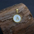 Golden round pendant with white mother-of-pearl shell and letter A on wooden background - Letter A / 17x20mm