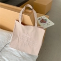 Nahaufnahme der rosa Stofftasche mit Bébé-Stickerei und Zitat zur Selbstpflege - Hellrosa