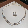 Macro shot of gold square crystal necklace and earrings set with starburst shimmer - Necklace + Earrings / Gold 2-Piece Set