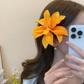 Detailed view of a large orange lily hair clip made of high-quality fabric on wavy hair - 36# Duckbill Clip - Orange - Orange Yellow Lily Style