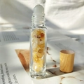 Glass essential oil roller bottle with yellow crystal stones and a wooden lid - Citrine