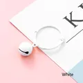 White resin bell keychain accessory with round clasp on a pastel background - White