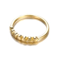 Detail shot of a polished gold minimalist ring featuring seven small circular disc elements - Seven Mini Discs