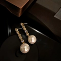 Detailed view of long gold drop earrings with white pearls and sparkling diamond accents - Gold (Style 28)