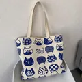 Crèmewitte canvas draagtas met blauwe kattenillustraties en lange handvatten op stoel - Japanse Kat Beige Dubbelzijdig