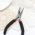 Detail of professional jewelry pliers with red and black handles on a soft feather background - Needle Nose Pliers (Serrated) / Black and Red Handle