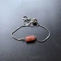 Armband mit silberner Kettenglied-Struktur und zylindrischem rosa-orangefarbenem Kristall - Erdbeerquarz