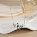 Detailed view of silver bird pendant with blue enamel and green teardrop zircons - FN0125 Silver Color Enamel Bird