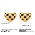 Detail view of 18k gold plated checkered heart earrings with dimensions 1.1cm x 1.4cm - Gold