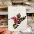 Detailed hummingbird brooch with vibrant pink and green rhinestones on silver-toned base - Antique Silver Pink + Green