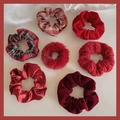 Détail de 7 chouchous rouges en tissus variés, carreaux et velours pour l'automne - Rouge