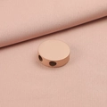 Detalle macro de cuenta redonda de acero inoxidable oro rosa con doble agujero en tela rosa - Oro rosa