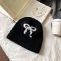 Detalle de gorro de punto mohair negro con lazo blanco y textura suave y esponjosa - Negro