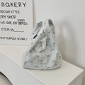Borsa da polso in tela azzurra con stampa floreale, pizzo bianco e manico annodato - Blu