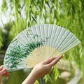 Traditional folding fan with green bamboo and bird motifs and grey silk tassel detail - Bird on Bamboo Branch