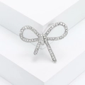Elegant silver bow brooch with crystal rhinestones on a clean geometric white background - Silver