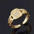 Bague dorée réglable avec zircons en forme de V et texture de chaîne sur fond noir - Lettre V