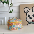Detailed texture of a quilted cotton floral makeup bag with colorful cartoon prints - Graffiti