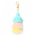 Detailed view of handmade three-layer cotton tassel in blue, pink, and yellow with gold clasp - Mint Green