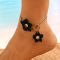 Elegant gold finish anklet with black floral pendants worn on beach background - Gold Chain Anklet with Black Flowers (3607)