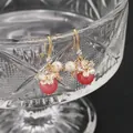 Barock-Edison-Perlenohrringe mit goldenen Blumenakzenten und roten Anhängern - Wassermelonenrot Naturstein