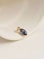 Macro view of a gold-plated oval pendant with marquise-cut blue zircon on a ceramic tray - September/Blue