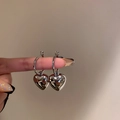 Detailed close-up of silver heart charm hoop earrings with polished metallic finish - Shiny Silver Heart Pendant Ear Buckle