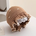Détail du bonnet tricoté pour bébé avec motif à pois bruns et bord à volants avec liens - 6 mois - 2 ans / Kaki