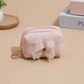Pink corduroy mini coin purse with lace bow, pearls, and a golden keychain on warm background - Pink