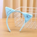 Detail of blue plush cat ear headband with cute monster pattern and Kvitfjell text logo - Blue Cat