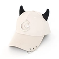 Close-up of cream baseball cap with black demon horns and moon star metal charms - Moon Beige