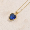 Elegante collar de corazón dorado con colgante de piedra azul sobre base de piedra - Circonita Azul Real