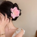 Detail of a pink gradient organza rose hair clip worn in a bun hair style. - Duckbill Hair Clips / Pink