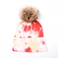 Détail d'un bonnet en tricot tie-dye avec pompon en fausse fourrure et texture douce - Teinture par Nouage Rose-Blanc