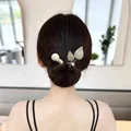 Détail de pinces à cheveux dorées élégantes avec perles et zircons sur une coiffure relevée chic - Doubles Feuilles Or