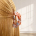 Macro shot of an amber-textured claw clip with marble patterns for securing hair - Style B Hollow (Orange-Blue Marble)