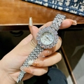 Luxury women's quartz watch with full crystal inlay and silver steel strap on wrist - Silver