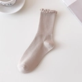 Ribbed beige cotton crew socks with ruffle cuff edge shown in minimalist setting - One Size / Khaki
