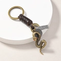 Detail of vintage anchor keychain with brown leather wrap and engraved quote tag - Snake