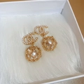 Vue macro de boucles d'oreilles vintage en or avec perles et sphère florale creuse - Style Lettre Doré (20#)