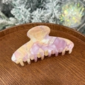 Gros plan d'une pince à cheveux en acétate marbré violet et rose sur plateau en bois - Violet Raisin & Beige - 8 Dents