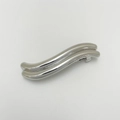 Close-up of wave-shaped silver alloy hair clip with polished metallic finish and punk style - Curved Wave Silver