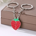 Detail of magnetic strawberry keychains with red enamel finish on a jewelry box - Two-Piece Set / Strawberry Keychain