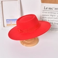 Detail eines roten Wollfilz-Fedoras mit passendem Band auf einem Holzständer - Erwachsene / Rot (Schleife)