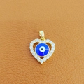 Golden heart-shaped Evil Eye pendant with micro-set zircons on brown leather backdrop - 14-Gold Heart Pave Blue Eye