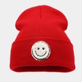 Detailopname van een rode gebreide muts met smiley-patch en gouden glitterrand - Rood